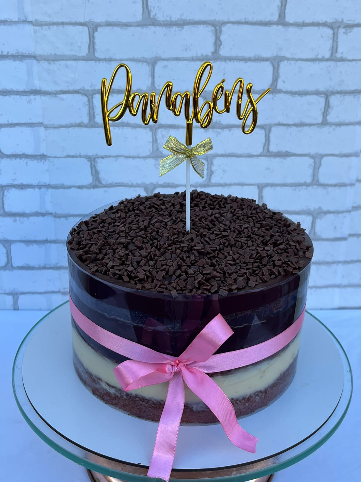 Bolo de chocolate com fita rosa e topo Parabéns