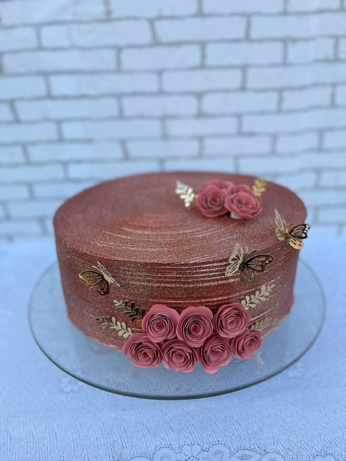Bolo rosé com glitter, rosas e borboletas douradas